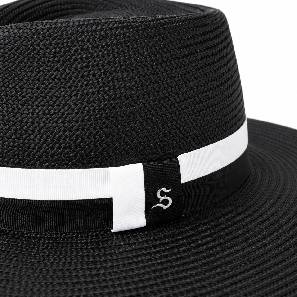 The frances black wide-brim Ecuadorian straw sunhat by Storm by Montecristi, featuring a contrast white and black grosgrain ribbon with a sterling silver logo.